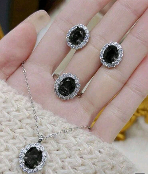 Black gemstone jewelry set with necklace and earrings on a hand